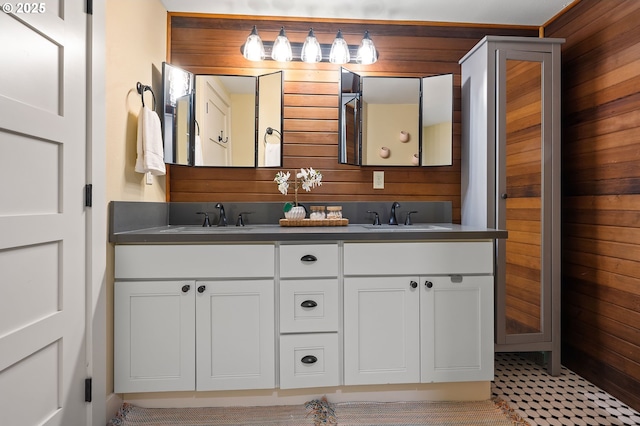 bathroom featuring double vanity, wood walls, and a sink