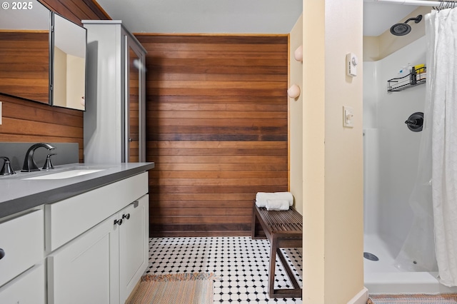 bathroom with wood walls, a shower stall, and vanity