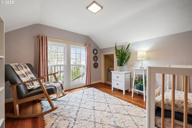 bedroom with access to outside, vaulted ceiling, baseboards, and wood finished floors