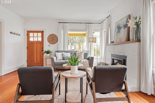 sitting room featuring a fireplace, wood finished floors, and baseboards