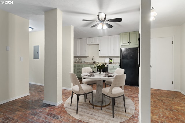 dining space featuring brick flooring, baseboards, ceiling fan, and electric panel