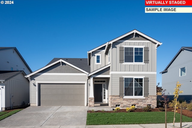 craftsman inspired home with concrete driveway, stone siding, board and batten siding, and an attached garage