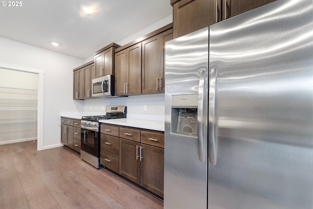 11383 NW 314th Ave, North Plains, OR 97133 - kitchen featuring appliances with stainless steel finishes, wood finished floors, light countertops, dark brown cabinetry, and recessed lighting