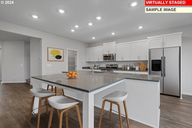 11383 NW 314th Ave, North Plains, OR 97133 - kitchen featuring stainless steel appliances, dark countertops, dark wood-type flooring, a kitchen breakfast bar, and recessed lighting