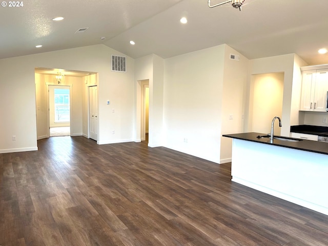 unfurnished living room featuring sink, vaulted ceiling, and dark hardwood / wood-style flooring