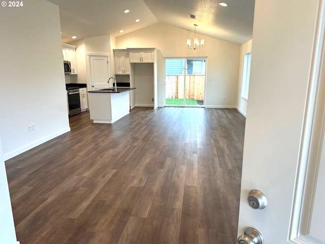 unfurnished living room featuring a textured ceiling, lofted ceiling, dark wood-type flooring, sink, and a notable chandelier