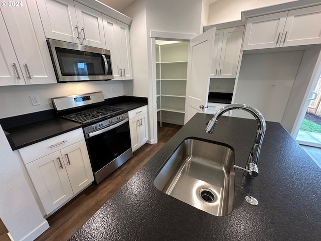 kitchen featuring sink, dark hardwood / wood-style floors, white cabinets, and appliances with stainless steel finishes