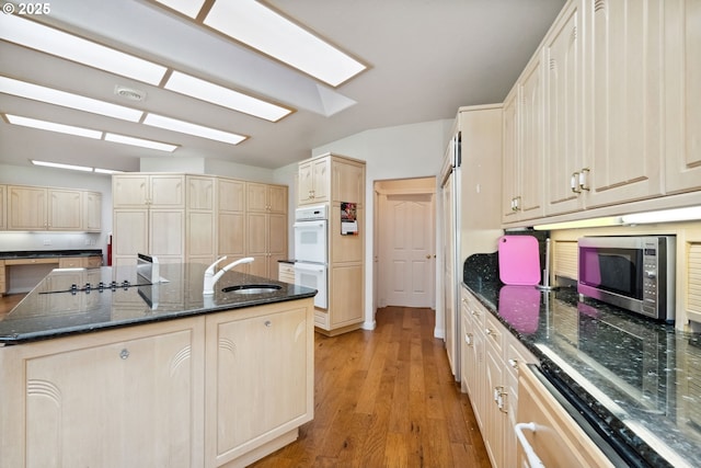 92631 Rainier Ln, Coos Bay, OR 97420 - kitchen with stainless steel microwave, double oven, light brown cabinetry, and a center island with sink
