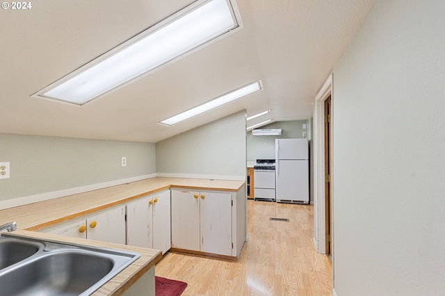 kitchen featuring white cabinets, lofted ceiling, sink, white appliances, and light hardwood / wood-style flooring