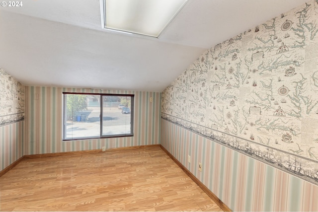 empty room featuring vaulted ceiling and light hardwood / wood-style flooring