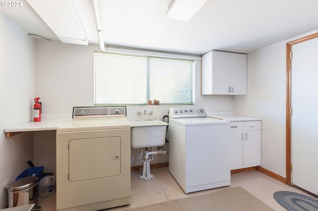 washroom featuring separate washer and dryer, cabinets, and sink