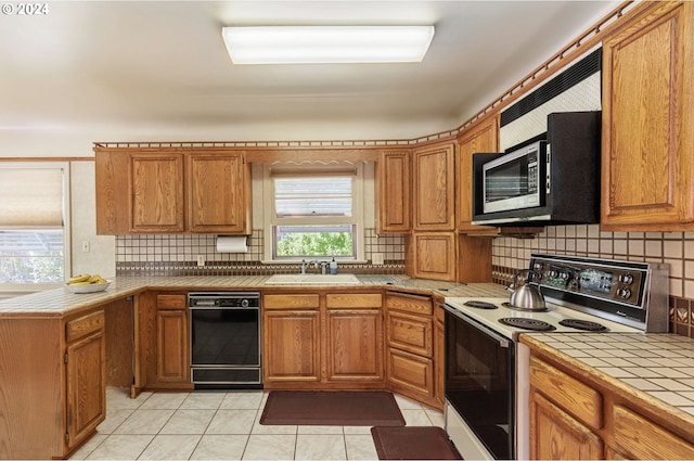 kitchen with tile countertops, sink, electric stove, light tile patterned floors, and dishwasher