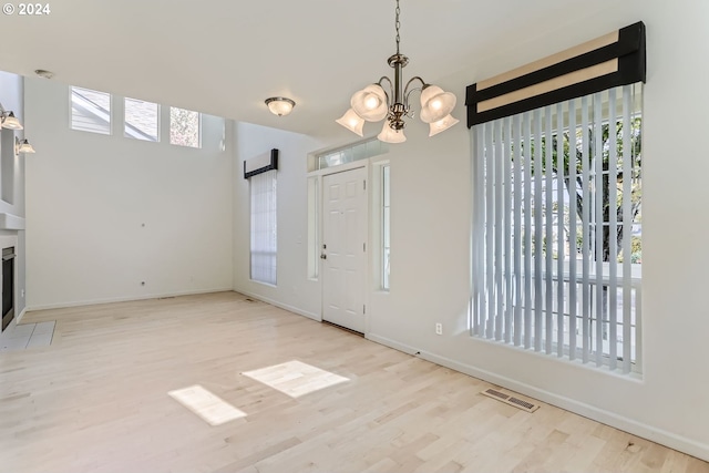 entrance foyer with a notable chandelier and light hardwood / wood-style flooring