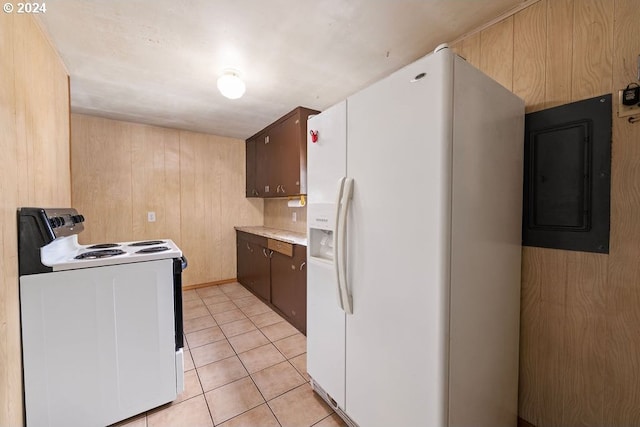 kitchen with wood walls, electric panel, dark brown cabinetry, white appliances, and light tile patterned flooring