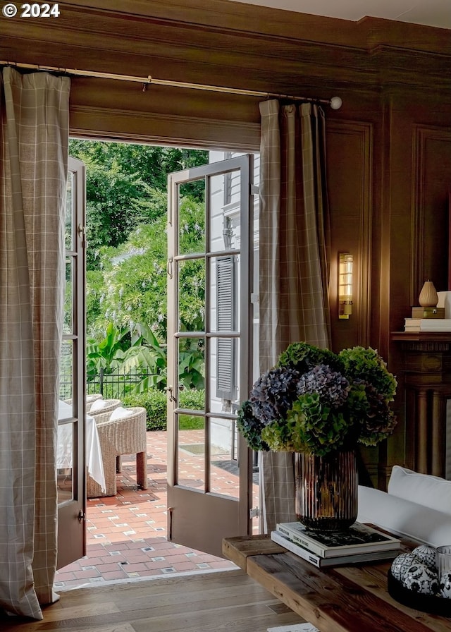 doorway featuring light hardwood / wood-style floors, wooden walls, and plenty of natural light