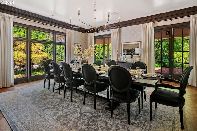 dining area with a notable chandelier, a wealth of natural light, and crown molding