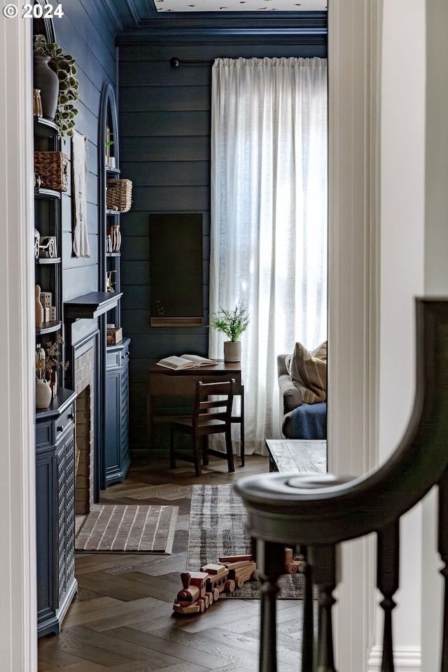 sitting room with wooden walls and dark parquet floors