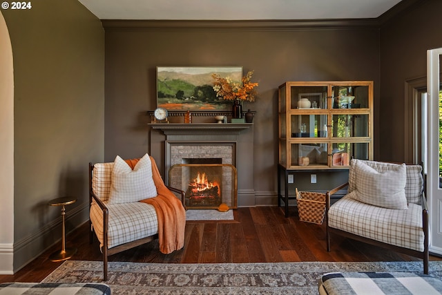 living area featuring ornamental molding, a brick fireplace, and dark hardwood / wood-style flooring