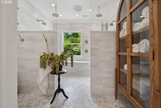 bathroom with ornamental molding, tile walls, tile patterned floors, and tiled shower