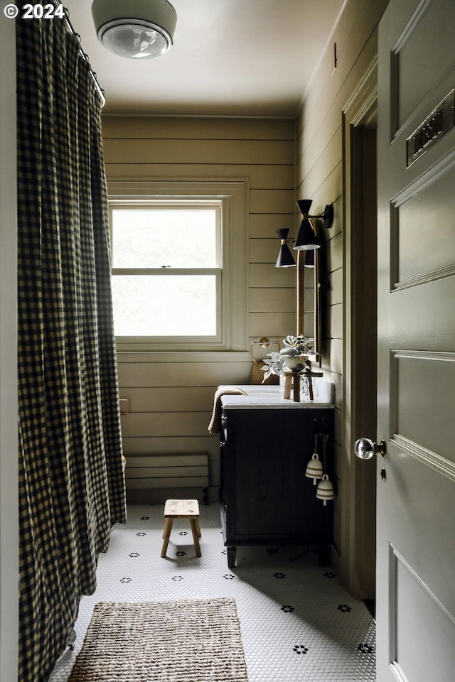 bathroom featuring vanity, wooden walls, and a shower with shower curtain