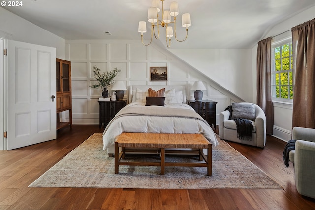 bedroom featuring an inviting chandelier, lofted ceiling, and dark hardwood / wood-style flooring