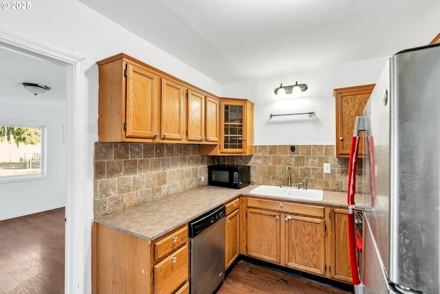 kitchen with dark hardwood / wood-style floors, sink, appliances with stainless steel finishes, and tasteful backsplash