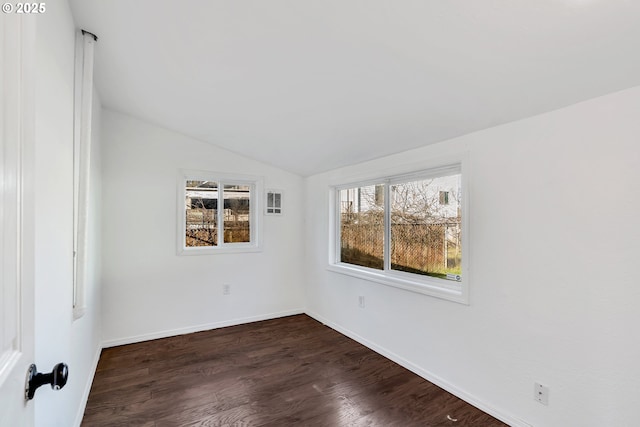 unfurnished room featuring dark wood-type flooring and lofted ceiling