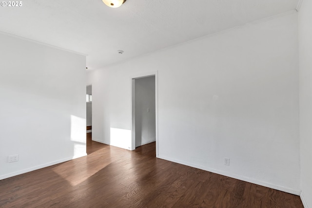 empty room featuring dark hardwood / wood-style flooring and crown molding