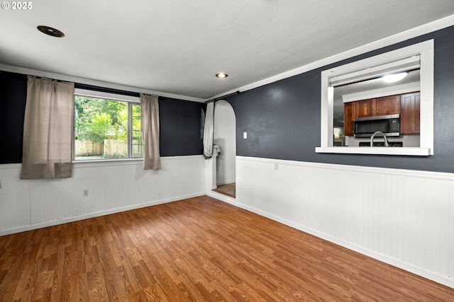 18021 Tualata Ave, Lake Oswego, OR 97035 - unfurnished room featuring wainscoting, arched walkways, and wood finished floors