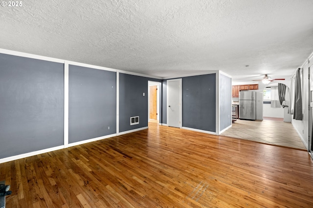 18021 Tualata Ave, Lake Oswego, OR 97035 - unfurnished living room featuring a textured ceiling, a ceiling fan, and light wood-style flooring