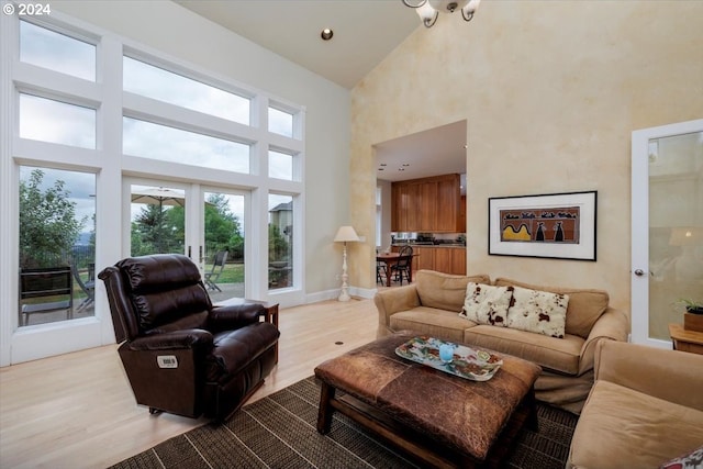 living room featuring french doors, high vaulted ceiling, and light wood-type flooring