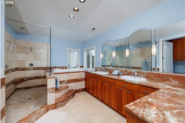 bathroom featuring plus walk in shower, vanity, and vaulted ceiling