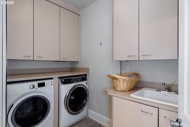 clothes washing area with cabinets, separate washer and dryer, and sink