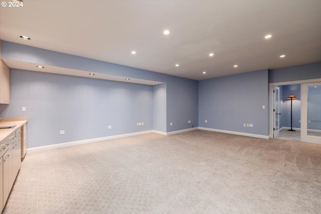 interior space featuring light carpet and sink