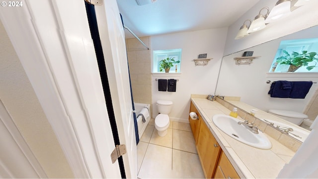 full bathroom featuring tile patterned floors, vanity, tiled shower / bath combo, and toilet