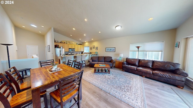 dining space with light hardwood / wood-style flooring and lofted ceiling