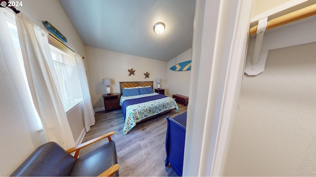 bedroom featuring hardwood / wood-style flooring and vaulted ceiling