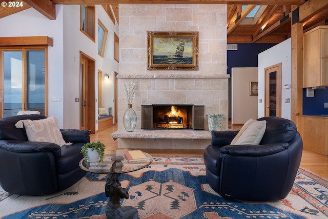 living room with a tiled fireplace, hardwood / wood-style flooring, and lofted ceiling with beams