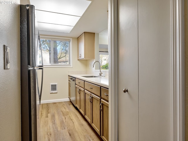 kitchen with plenty of natural light, appliances with stainless steel finishes, sink, and light wood-type flooring