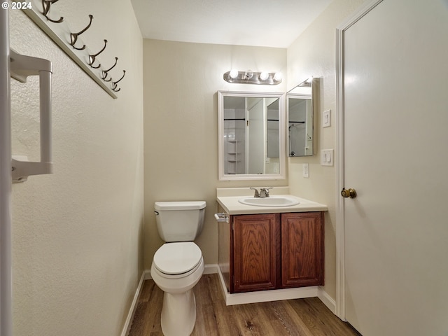 bathroom with vanity, wood-type flooring, and toilet