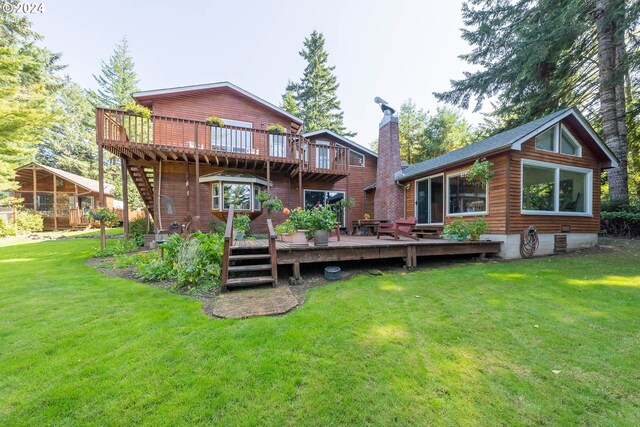 back of property featuring a lawn and a wooden deck