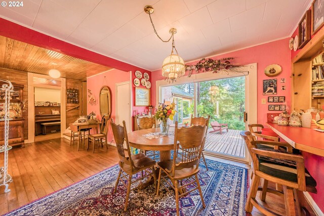 dining room featuring a notable chandelier, hardwood / wood-style flooring, and wood ceiling