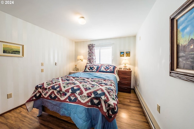 bedroom featuring baseboard heating and wood-type flooring