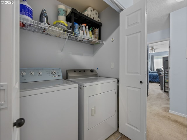 clothes washing area featuring light colored carpet, washer and clothes dryer, and laundry area