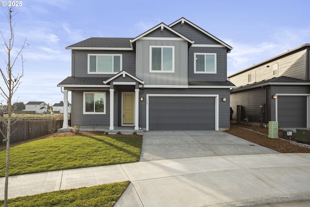 view of front of property featuring board and batten siding, fence, a front yard, driveway, and an attached garage