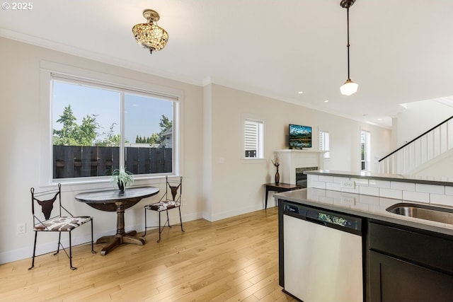 kitchen with dishwashing machine, plenty of natural light, light wood-style flooring, and crown molding