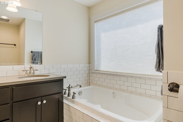 full bathroom featuring a bath, visible vents, vanity, and a healthy amount of sunlight