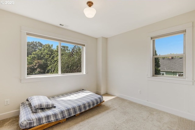 sitting room featuring a wealth of natural light, baseboards, visible vents, and carpet flooring