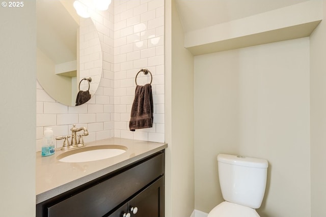 bathroom featuring tasteful backsplash, vanity, and toilet