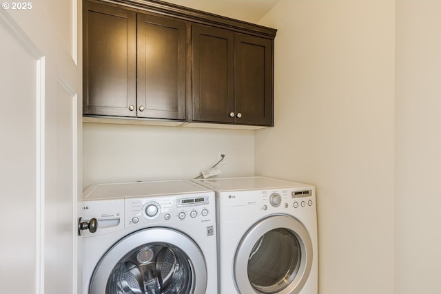 laundry room with washing machine and dryer and cabinet space